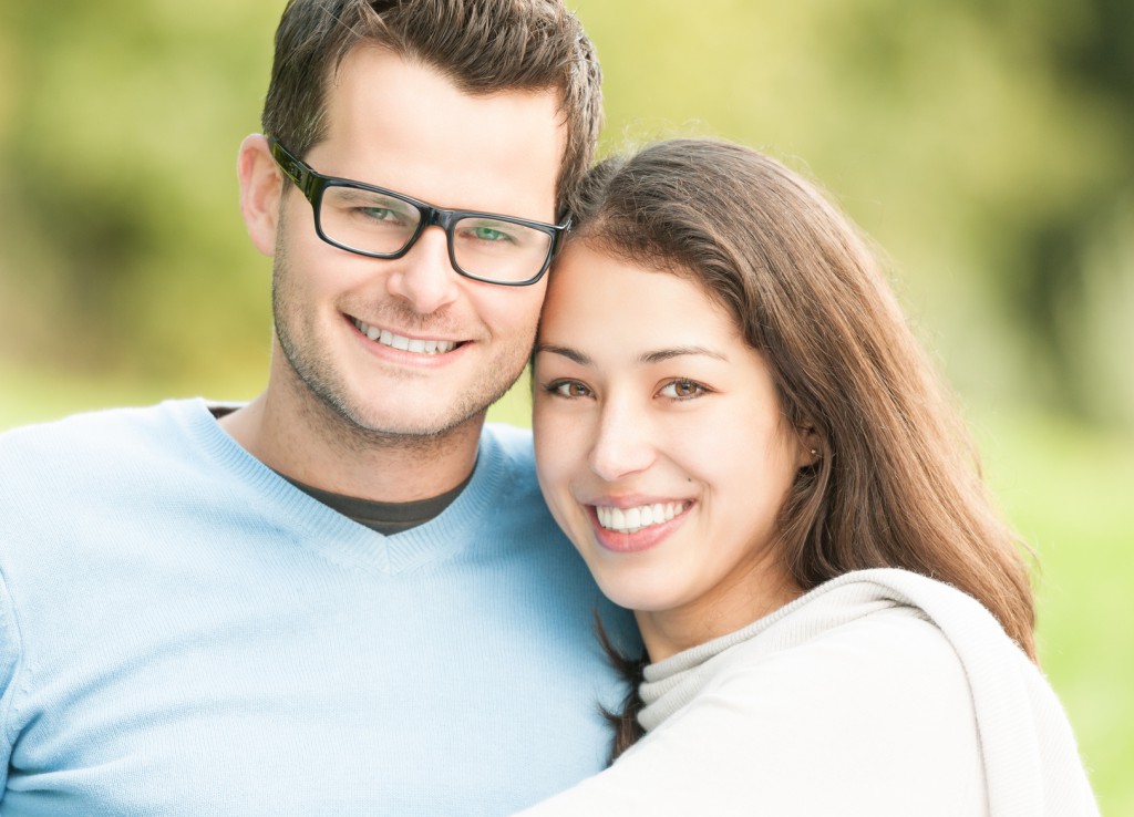 Portrait of happy young man and woman in park.